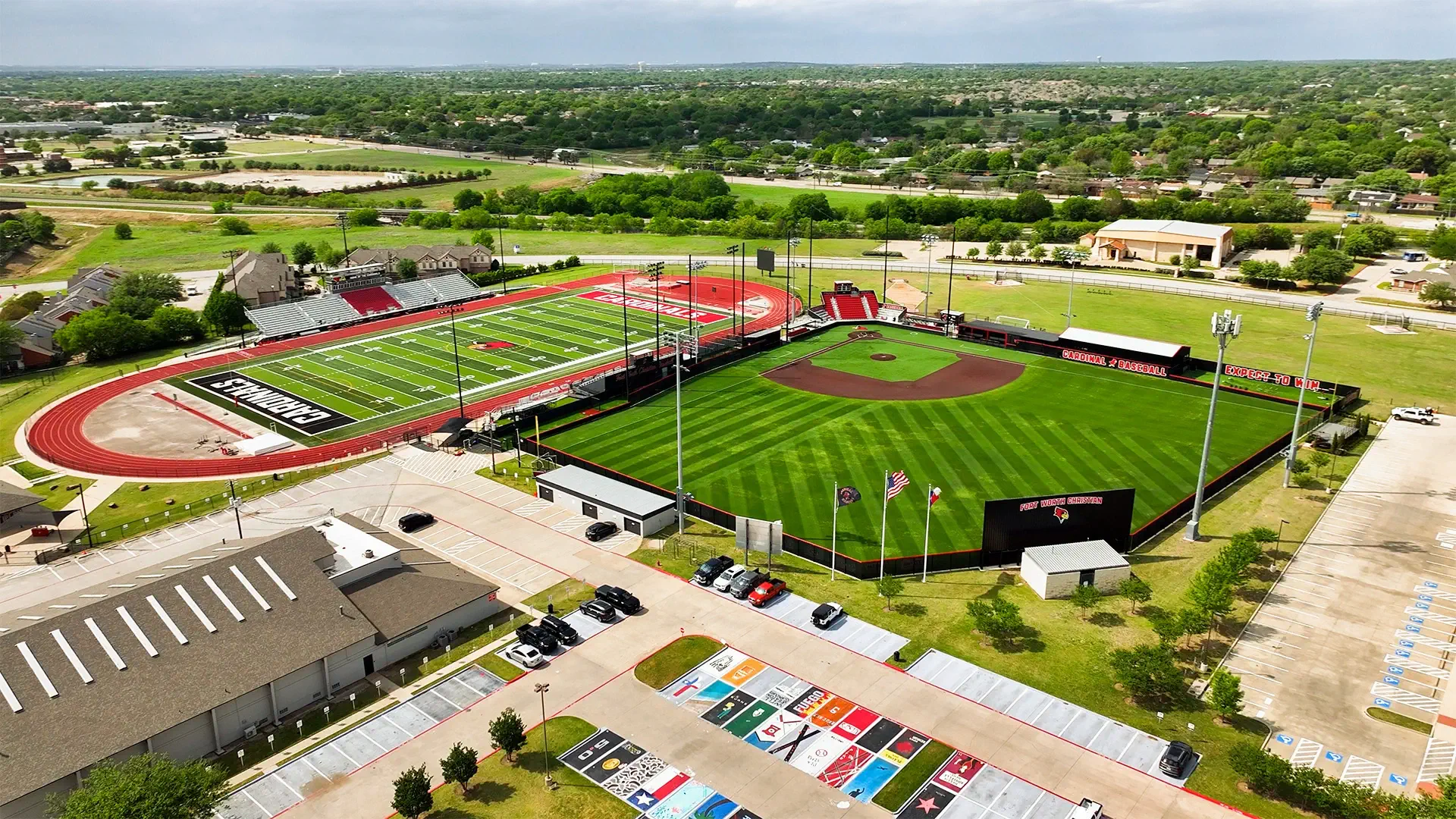 Aerial view of a school athletic complex with maintained sports fields and running track