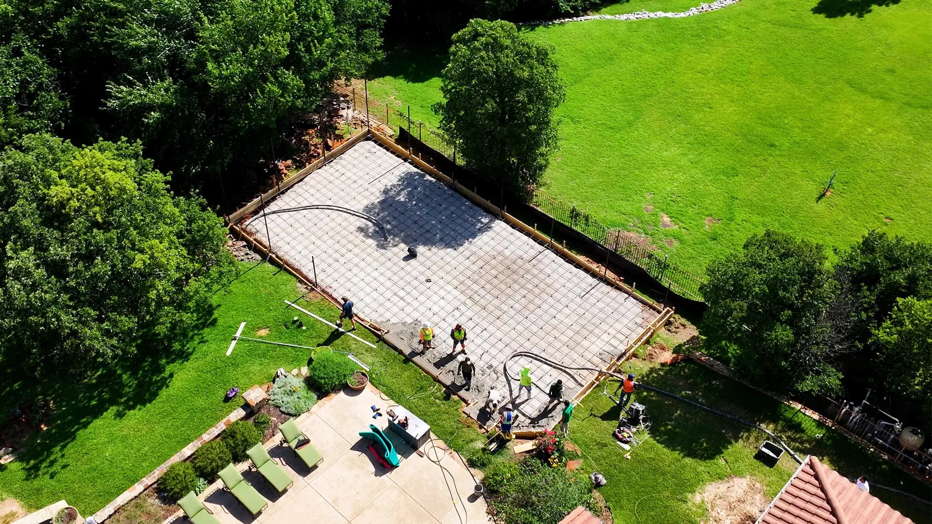 Crew pouring the reinforced concrete slab for a backyard pickleball court